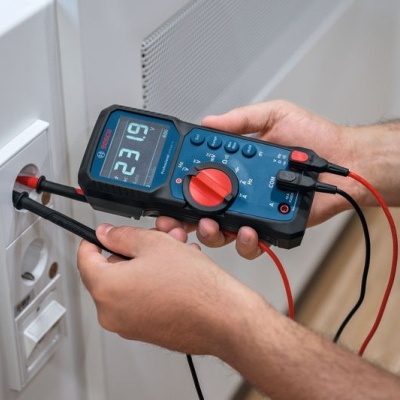 Multímetro digital a medir voltagem numa tomada de parede