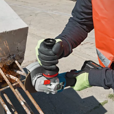 Esmerilhadora elétrica a cortar barras metálicas enferrujadas em cimento