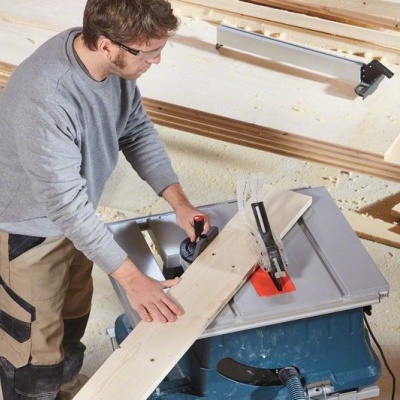 Homem a usar serra circular elétrica para cortar madeira