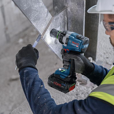 Parafusadeira Bosch a bateria em uso por trabalhador de construção com equipamento de segurança