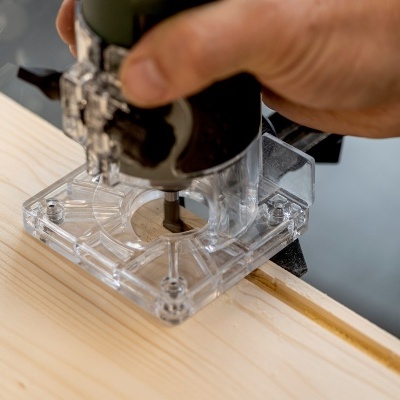 Ferramenta elétrica manual a trabalhar folha de madeira clara