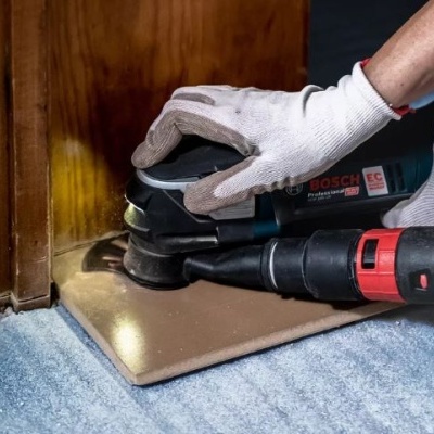 Pessoa a lixar superfície de madeira com lixadeira elétrica Bosch