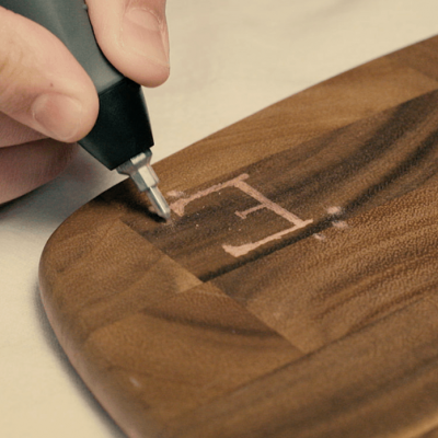 Gravação de letra em madeira escura com padrão em madeira clara