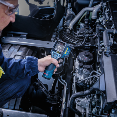 Sensor de temperatura Bosch com ecrã digital na mão de técnico junto a motor automóvel