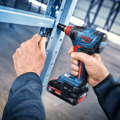 Parafusadeira Bosch azul e preta com vermelho a ser usada para montar estrutura metálica azul claro