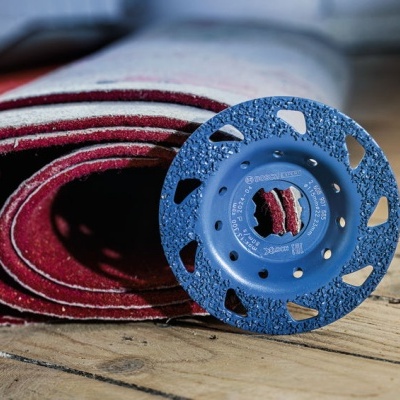 Disco de diamante azul para corte sobre rolo de lixa vermelho em chão de madeira
