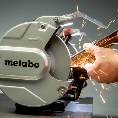 Máquina de corte Metabo cinzenta a cortar tubo metálico com faíscas