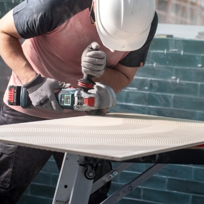 Pessoa a polir placa branca com ferramenta elétrica