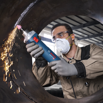 Homem a esmerilhar peça metálica com ferramenta Bosch numa fábrica