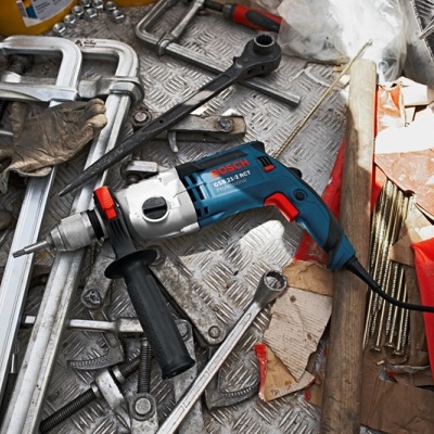 Furadeira Bosch azul e ferramentas em superfície metálica