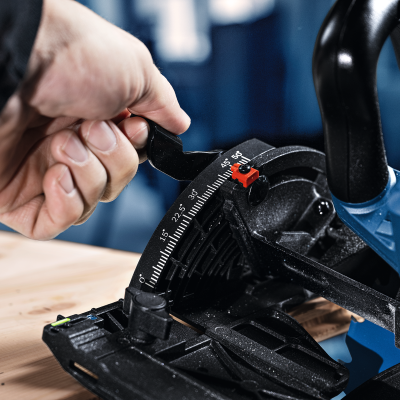 Serra circular azul com ajuste de ângulo de corte e mão a manipular alavanca preta