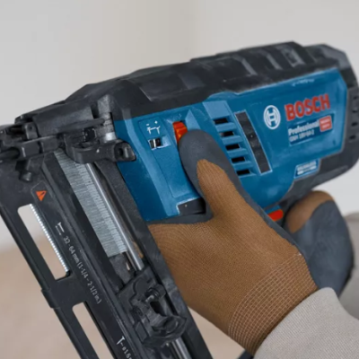 Máquina de pregos Bosch Professional azul e preta com luva castanha