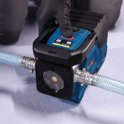 Bomba de água portátil azul e preta com visor e botão vermelho em superfície cinza