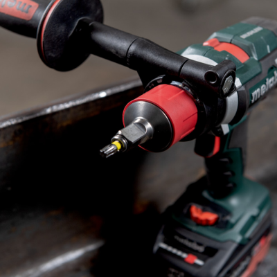Parafusadeira Metabo com punho vermelho e preto a aparafusar numa peça metálica
