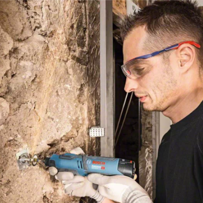 Homem a usar ferramenta Bosch para perfurar parede