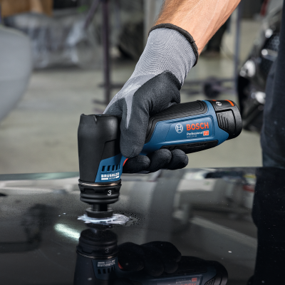 Esmerilhadeira Bosch azul e preta a ser usada numa superfície preta refletora