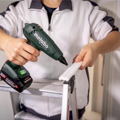 Pessoa usando ferramenta elétrica Metabo numa escada aplicando peça plástica