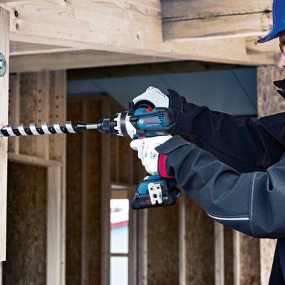 Homem a utilizar furadeira numa estrutura de madeira