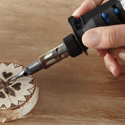 Ferramenta de pirografia DREMEL queimando padrão de corações numa fatia de madeira