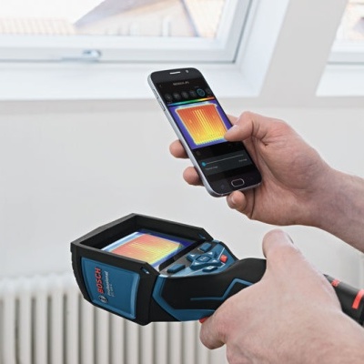 Aparelho de termografia Bosch azul e preto com smartphone mostrando imagem térmica, em ambiente interior