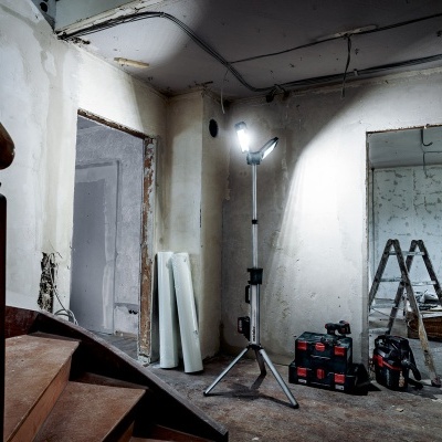 Espaço interior em construção com escada, luz de trabalho e ferramentas