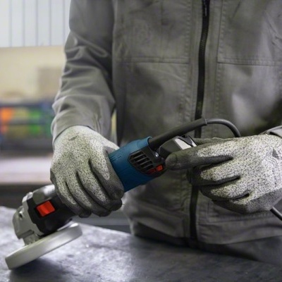 Polidor elétrico azul e preto segurado por trabalhador com luvas e fato cinza