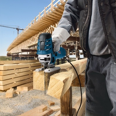 Serra de recortes azul e preto a cortar madeira num estaleiro de construção