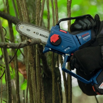 Moto serra elétrica azul e preta BOSCH GSA 18V-32 a cortar galhos de árvore