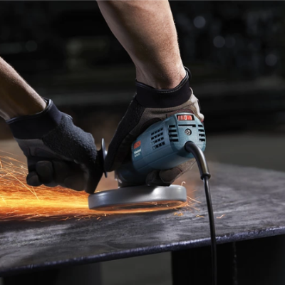 Pessoa usando esmerilhadora elétrica em peça metálica gerando faíscas