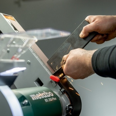 Pessoa afiando uma faca com máquina Metabo BG 20 PRG, faíscas visíveis