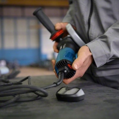 Máquina de esmerilar eléctrica azul e preto numa oficina