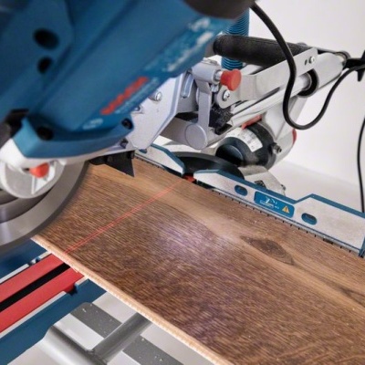 Serra de corte elétrica azul a cortar madeira numa oficina