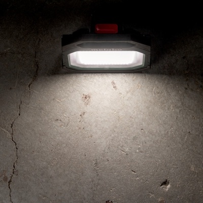 Luz de parede retangular a emitir luz branca montada em parede de cimento cinzento