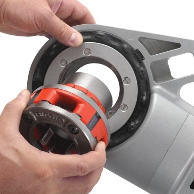 pessoa a montar equipamento metálico cinza, preto e vermelho