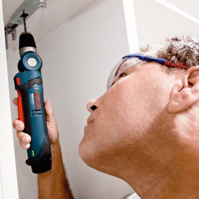 Homem com óculos de proteção a usar ferramenta elétrica Bosch