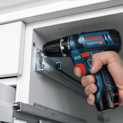 Parafusadora BOSCH Professional azul e vermelha numa gaveta branca