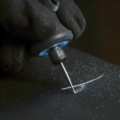 Máquina elétrica gravando numa superfície preta.