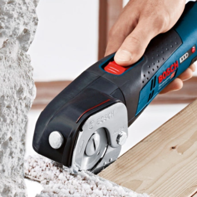 Ferramenta elétrica BOSCH GSA 18 V-LI C cortando madeira numa bancada ao lado de parede de pedra