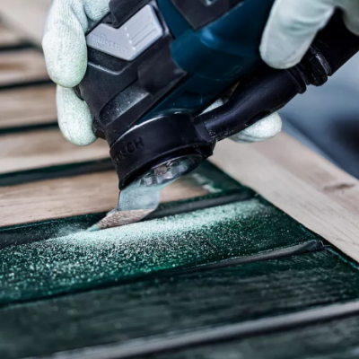 Lixadeira elétrica a lixar madeira verde com mãos com luvas