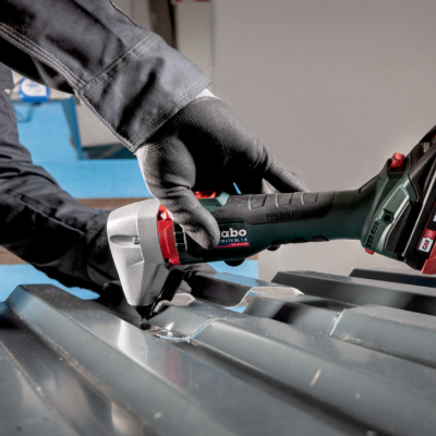 Ferramenta elétrica sem fios Metabo cortando chapa metálica ondulada