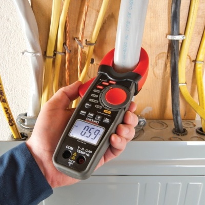 Alicate amperímetro digital RIDGID sendo usado em instalação elétrica com cabos coloridos