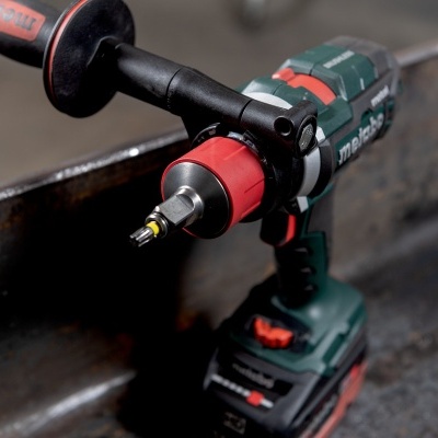 Parafusadeira Makita preta e verde com punho vermelho e preto, em estrutura metálica.