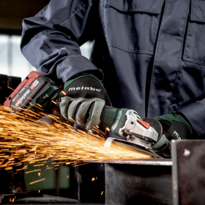 Pessoa a usar esmerilhadora Metabo em peça de metal com faíscas num ambiente industrial