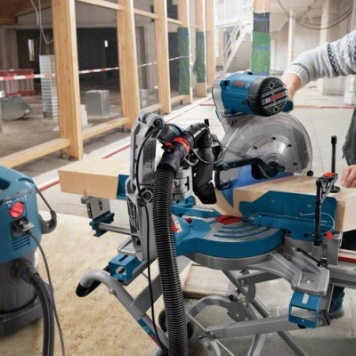 Serra de corte com lâmina circular e operador numa oficina de construção