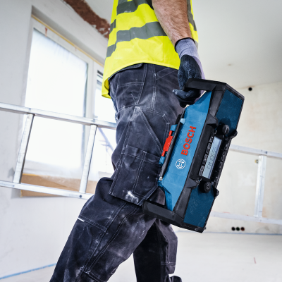 Homem com rádio portátil BOSCH num ambiente de construção interior