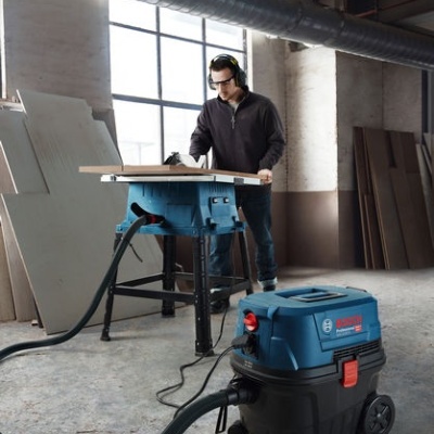 Máquina de carpintaria Bosch Professional azul e preto em ambiente industrial com homem a trabalhar