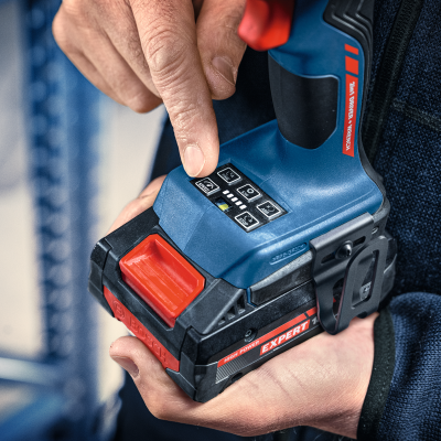 Pessoa a segurar uma ferramenta elétrica azul e preta com detalhes vermelhos, marca BOSCH e etiquetas EXPERT e HIGH POWER