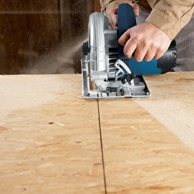 Serra circular a cortar madeira clara numa oficina