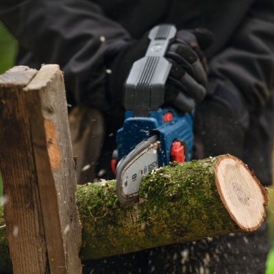 Motosserra elétrica azul e preta a cortar tronco exterior
