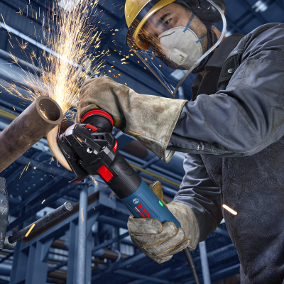 Trabalhador a cortar tubo metálico com rebarbadora Bosch em ambiente industrial
